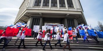 Участники торжественного митинга по случаю празднования годовщины "Крымской весны" на площади у Государственного Совета РК в городе Симферополе