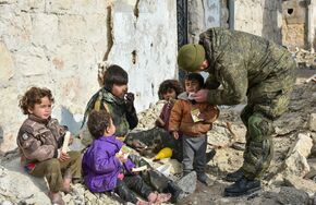 Военные инженеры сводного отряда Международного противоминного центра Вооруженных сил РФ, продолжающие работу по разминированию восточных районов сирийского города Алеппо, на одной из улиц Алеппо с сирийскими детьми