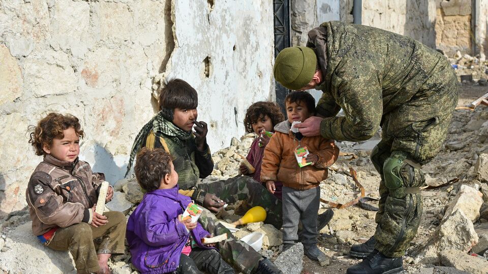 Военные инженеры сводного отряда Международного противоминного центра Вооруженных сил РФ, продолжающие работу по разминированию восточных районов сирийского города Алеппо, на одной из улиц Алеппо с сирийскими детьми