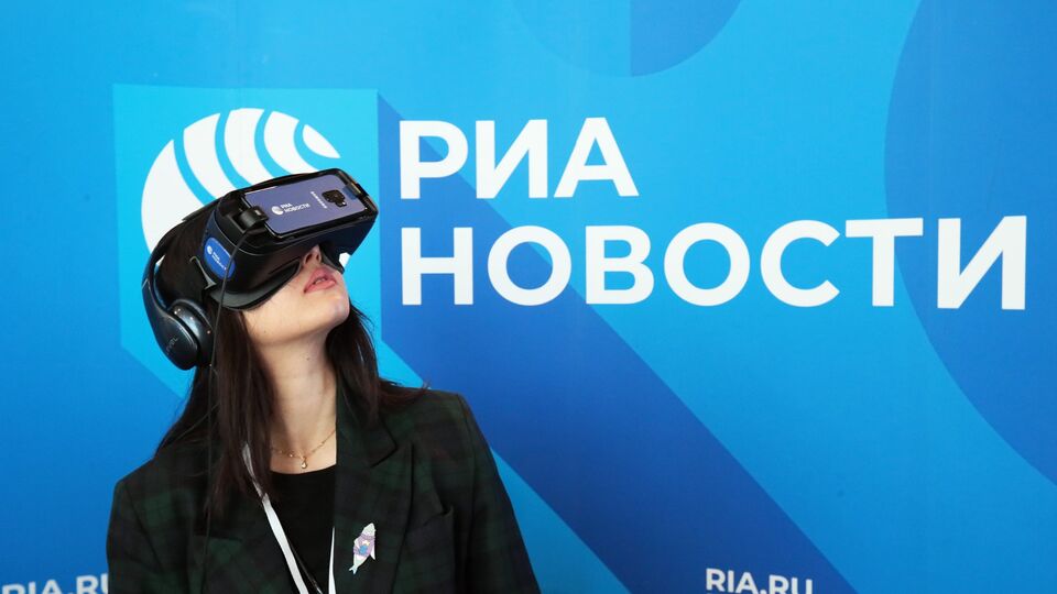 Девушка использует VR очки на стенде МИА "Россия сегодня"