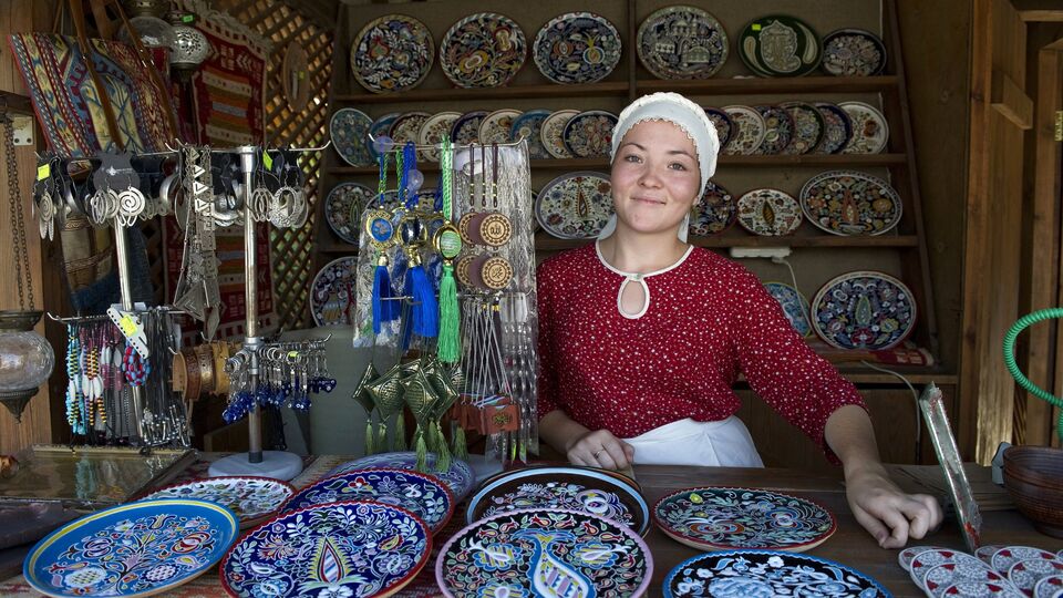 Продавец сувенирной лавки с настенными тарелками в городе Евпатории