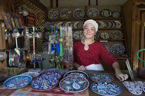Продавец сувенирной лавки с настенными тарелками в городе Евпатории